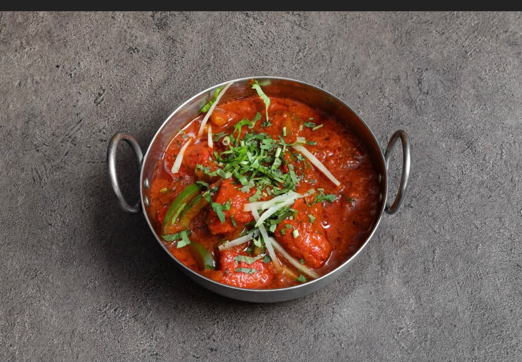 Chicken karahi garnished with coriander and ginger