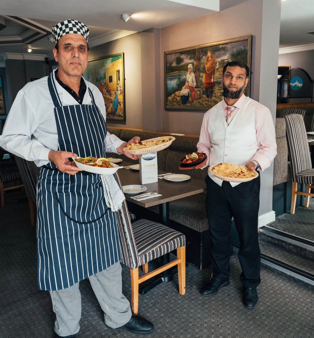 Our chef and waiter presenting freshly prepared dishes in the dining room